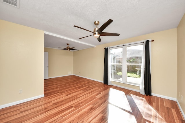 unfurnished room with ceiling fan, light hardwood / wood-style flooring, and a textured ceiling