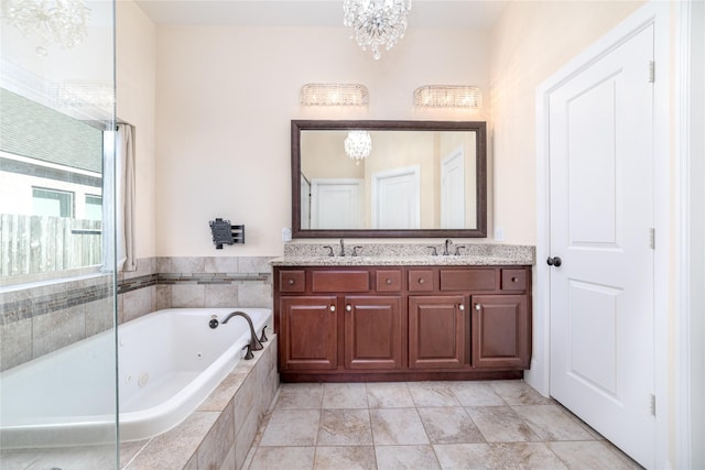 bathroom with a notable chandelier, tiled tub, and vanity