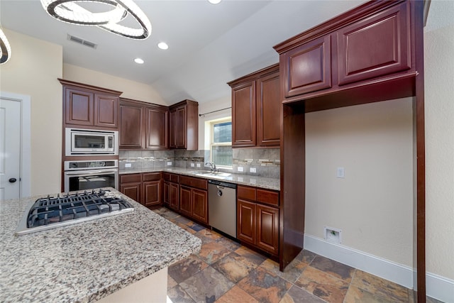 kitchen with pendant lighting, sink, appliances with stainless steel finishes, tasteful backsplash, and light stone counters