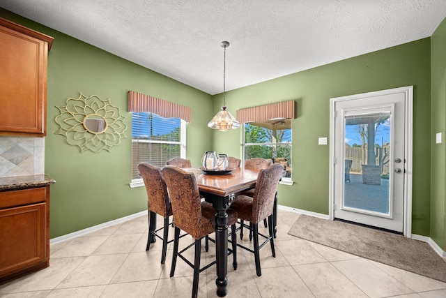 dining space with light tile patterned floors, a textured ceiling, and an inviting chandelier