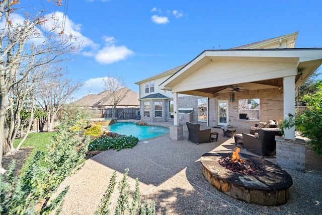 view of swimming pool featuring a patio, ceiling fan, and an outdoor living space with a fire pit