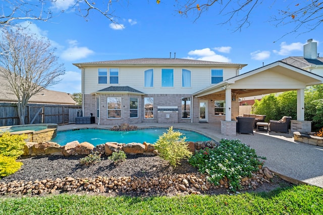 back of house featuring a swimming pool with hot tub, an outdoor hangout area, and a patio area