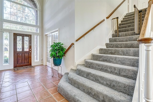 tiled entrance foyer featuring a towering ceiling