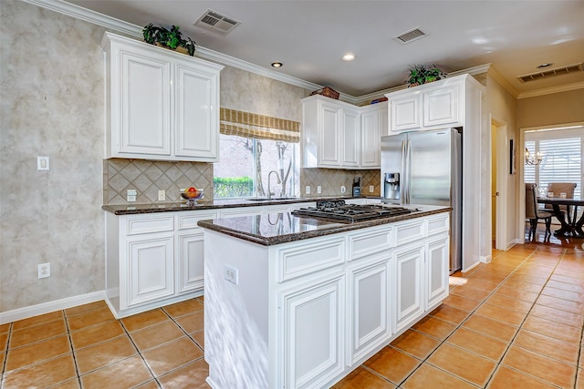 kitchen featuring sink, dark stone countertops, appliances with stainless steel finishes, a kitchen island, and white cabinetry