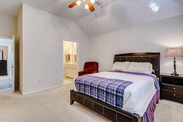 bedroom featuring ceiling fan, ensuite bathroom, light colored carpet, and vaulted ceiling