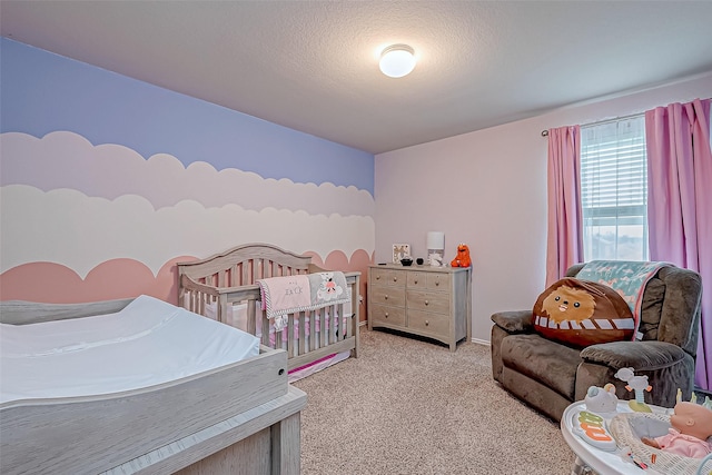 bedroom featuring a textured ceiling, light colored carpet, and a crib