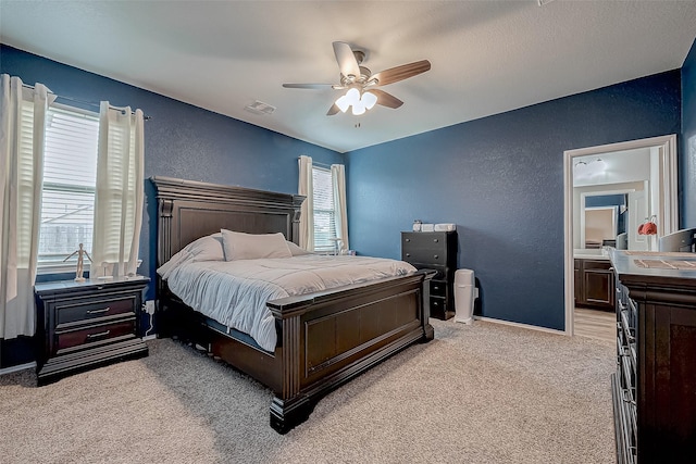 carpeted bedroom with ceiling fan, connected bathroom, and multiple windows