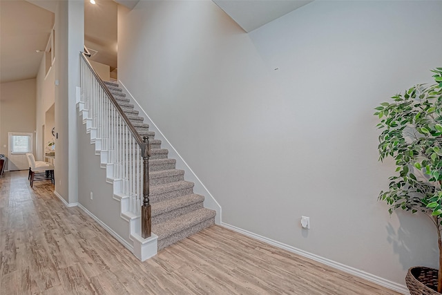 stairs with a high ceiling and hardwood / wood-style floors