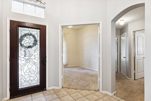 carpeted foyer entrance featuring a textured ceiling