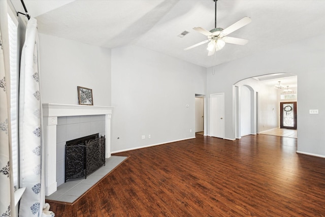 unfurnished living room featuring ceiling fan, plenty of natural light, a tiled fireplace, and light hardwood / wood-style flooring