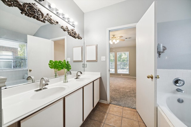 bathroom featuring a bathing tub, ceiling fan, tile patterned flooring, vaulted ceiling, and vanity