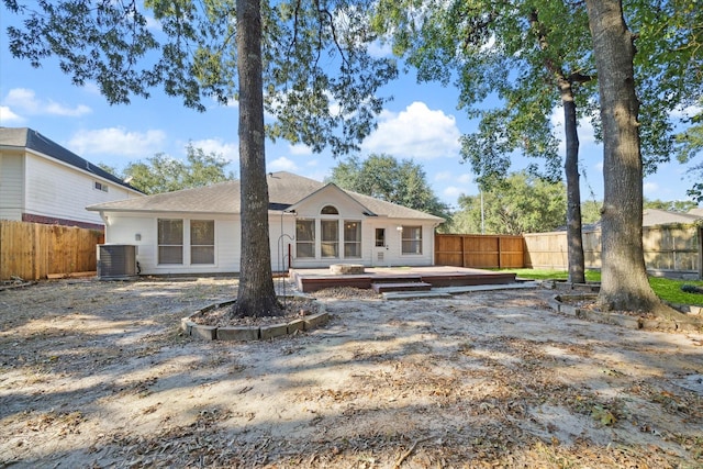 rear view of property featuring a wooden deck and cooling unit