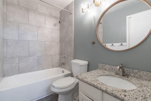 full bathroom with vanity, tiled shower / bath combo, and toilet