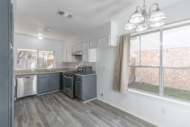 kitchen featuring appliances with stainless steel finishes, gray cabinetry, sink, a chandelier, and hanging light fixtures