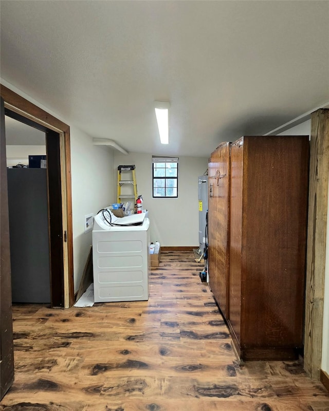 washroom with washer / clothes dryer, hardwood / wood-style flooring, and water heater