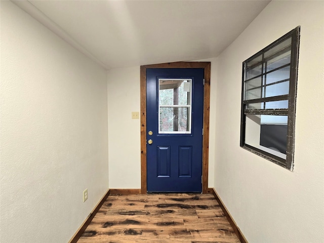 doorway to outside featuring dark hardwood / wood-style flooring and lofted ceiling