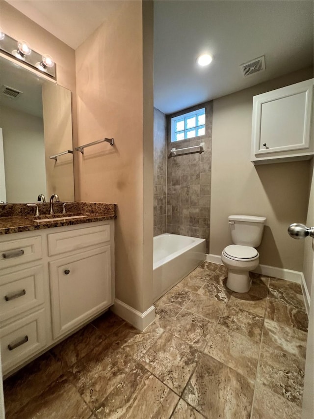 full bathroom featuring vanity, tiled shower / bath combo, and toilet