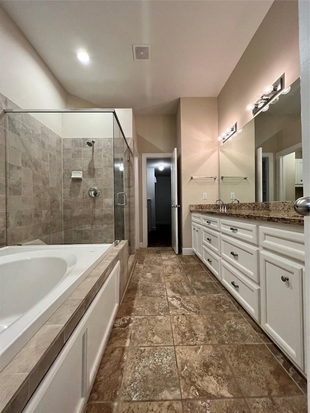 bathroom with vanity and shower with separate bathtub