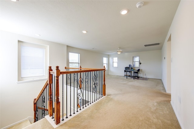 corridor featuring light colored carpet