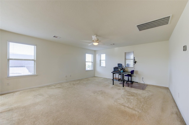 spare room featuring light carpet and ceiling fan