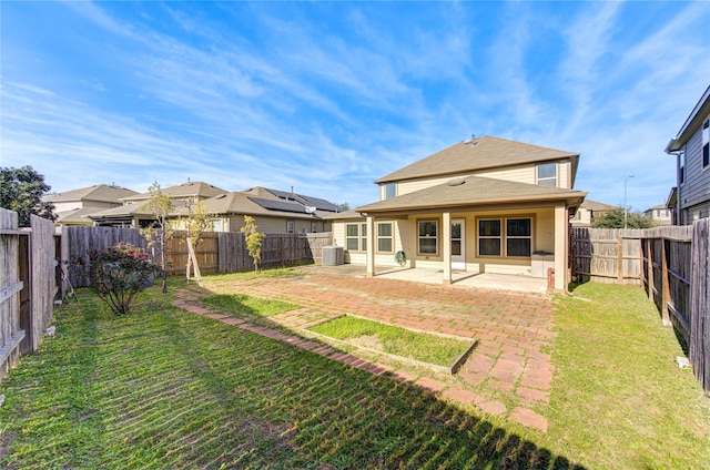 rear view of house with a lawn, cooling unit, and a patio