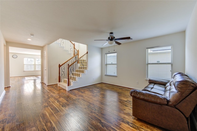 living room with dark hardwood / wood-style flooring and ceiling fan