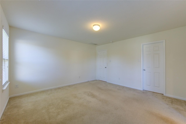 carpeted spare room featuring plenty of natural light