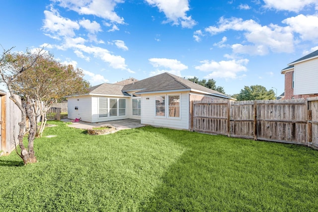 back of house with a patio area and a yard