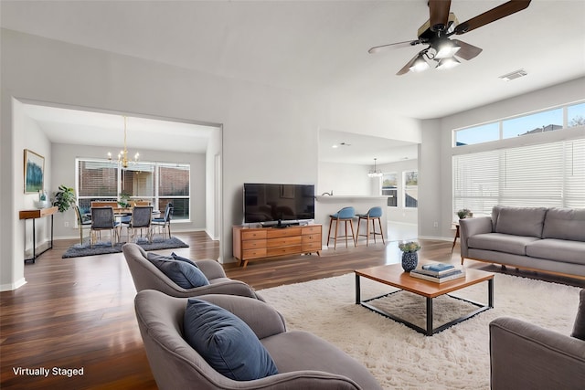 living room featuring ceiling fan with notable chandelier and dark hardwood / wood-style floors