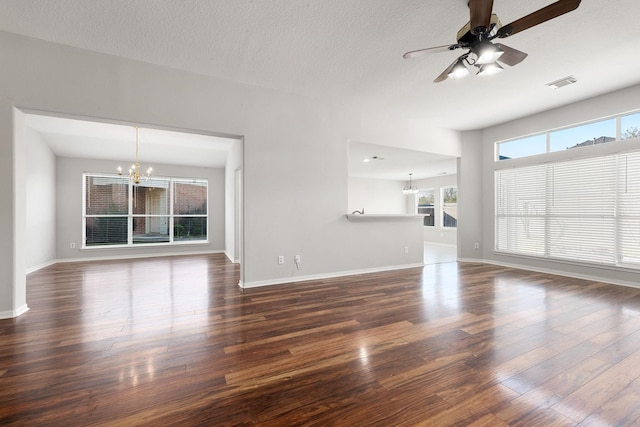 unfurnished living room with a textured ceiling, dark hardwood / wood-style flooring, and ceiling fan with notable chandelier