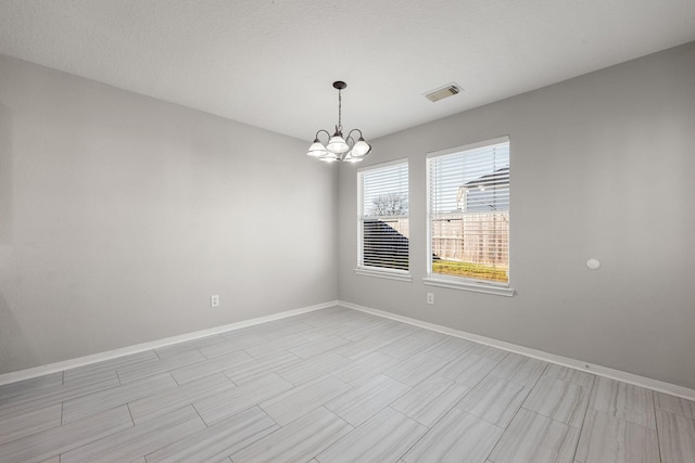 empty room featuring an inviting chandelier