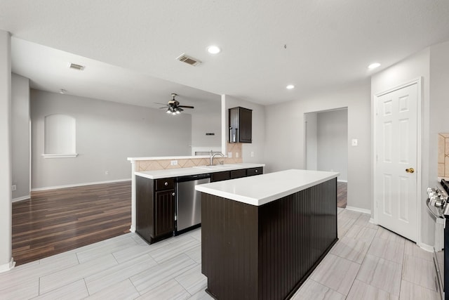 kitchen with a center island, stainless steel appliances, ceiling fan, and sink