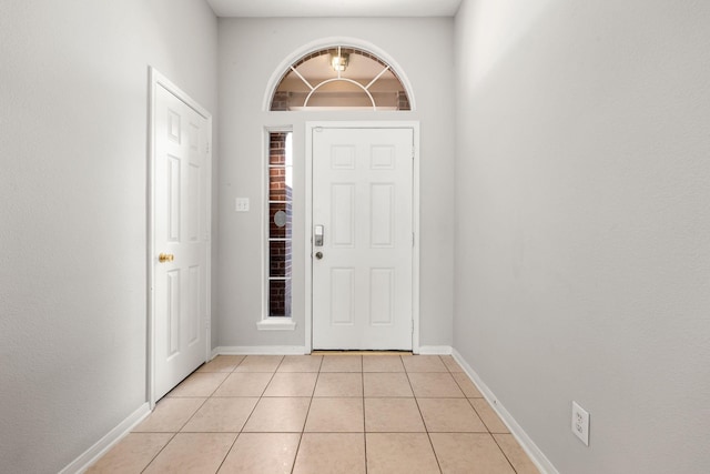 entrance foyer featuring light tile patterned floors and a towering ceiling