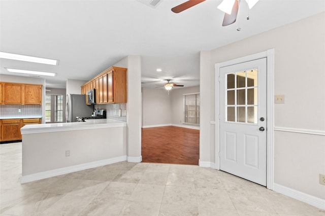 kitchen featuring tasteful backsplash, light tile patterned floors, and stainless steel appliances