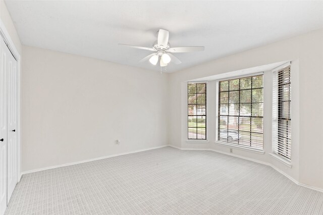 spare room featuring ceiling fan and light colored carpet