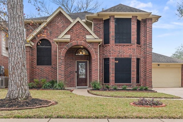 view of front of house with a front lawn, central AC unit, and a garage