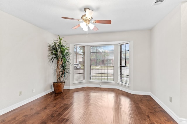 empty room with ceiling fan and dark wood-type flooring