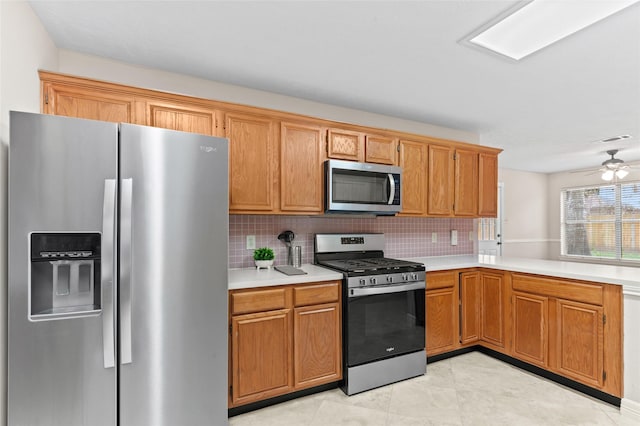 kitchen with decorative backsplash, ceiling fan, light tile patterned flooring, and appliances with stainless steel finishes