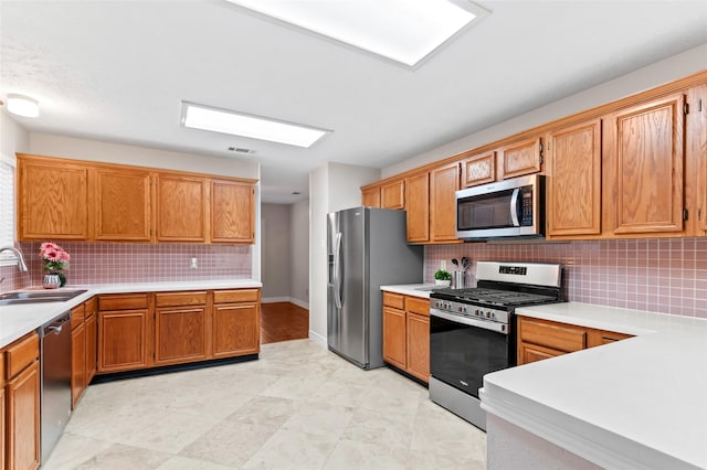 kitchen featuring sink, appliances with stainless steel finishes, and tasteful backsplash