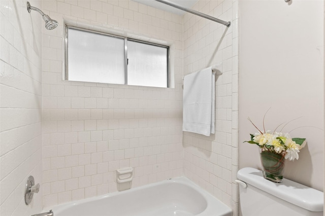 bathroom with toilet and tiled shower / bath