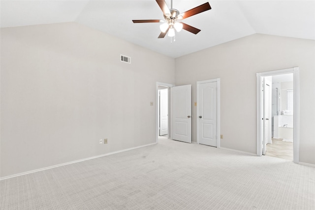 unfurnished bedroom with connected bathroom, ceiling fan, high vaulted ceiling, and light carpet