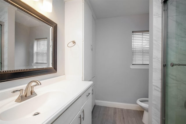 bathroom featuring plenty of natural light, vanity, an enclosed shower, and toilet