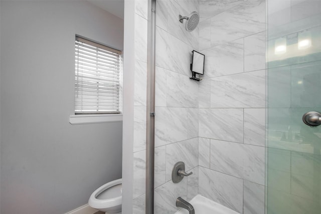 bathroom with toilet and shower / bath combination with glass door