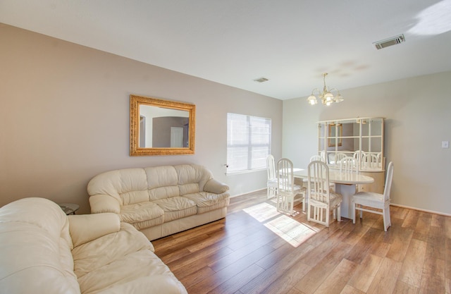 living room featuring hardwood / wood-style flooring and an inviting chandelier