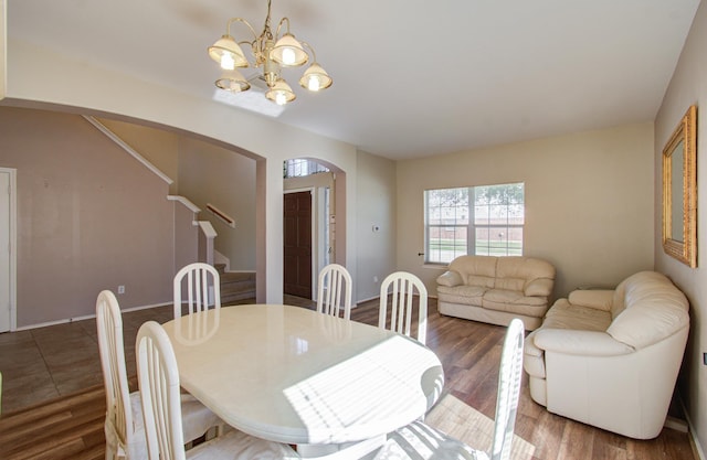 dining room with dark hardwood / wood-style floors and an inviting chandelier