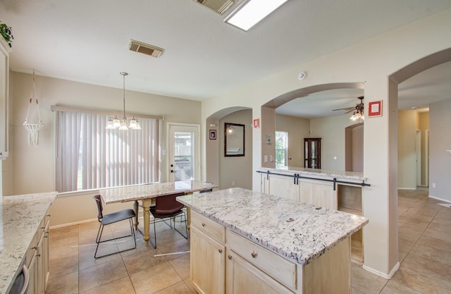 kitchen with a center island, pendant lighting, light brown cabinetry, light tile patterned floors, and ceiling fan with notable chandelier