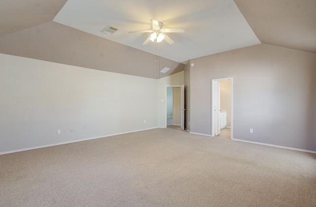 interior space featuring ensuite bathroom, vaulted ceiling, ceiling fan, and light colored carpet