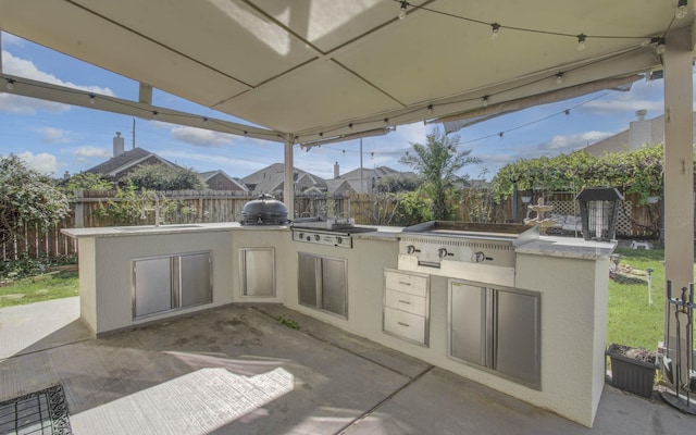 view of patio featuring exterior kitchen, sink, and grilling area