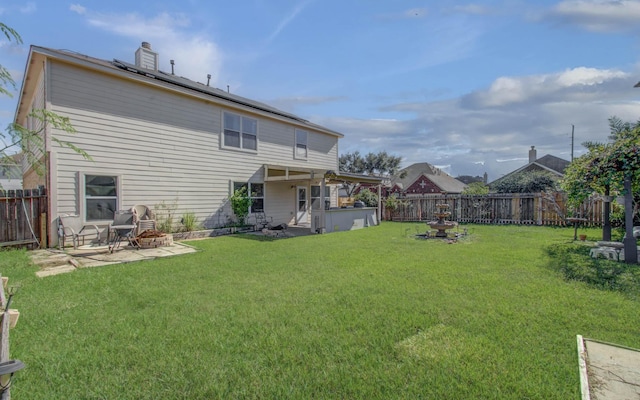 rear view of house featuring a lawn and a patio