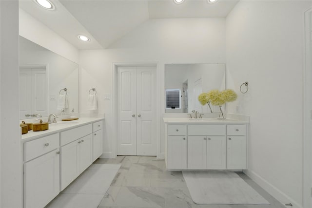 bathroom featuring lofted ceiling and vanity